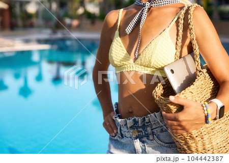 Young happy woman going to work with laptop in summer sunny day near the pool 104442387