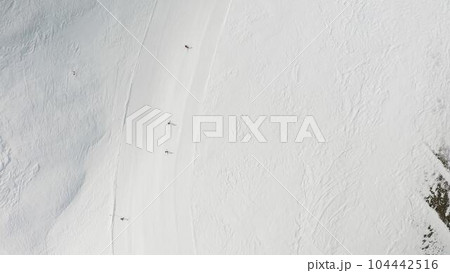 People snowboarding skiing at ski resort. Skiers, snowboarders riding snowy mountain slope. Outdoor winter sport. Aerial, top view 104442516