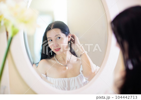 Young Asian woman looking in the mirror. 104442713