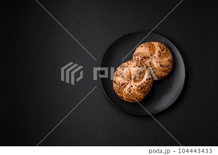 Delicious freshly baked crispy bun or kaiser roll with sesame seeds 104443433