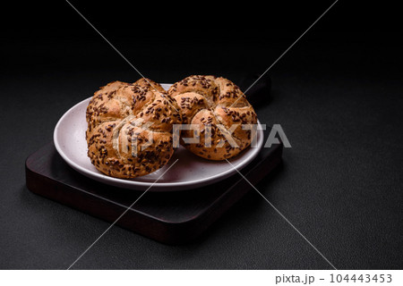 Delicious freshly baked crispy bun or kaiser roll with sesame seeds 104443453