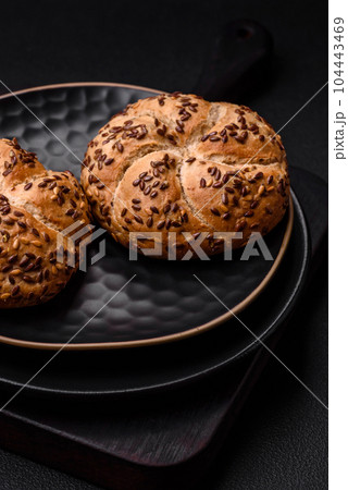 Delicious freshly baked crispy bun or kaiser roll with sesame seeds Delicious freshly baked crispy bun or kaiser roll with sesame seeds 104443469