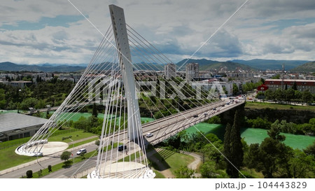 Aerial shot of the Millennium Bridge, a cable-stayed bridge and the Moracha river in Podgorica, Montenegro Aerial shot of the Millennium Bridge, a cable-stayed bridge and the Moracha river in Podgorica, Montenegro 104443829