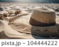 Wicker straw hat on beach sand. Summer sea vacation concept 104444222