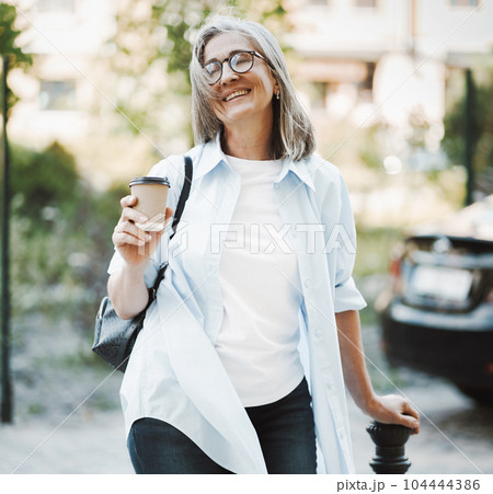 Woman in good mood, radiating happiness and contentment with life. The image features lady standing on a street, exuding joyful and carefree demeanor. . High quality photo Woman in good mood, radiating happiness and contentment with life. The image features lady standing on a street, exuding joyful and carefree demeanor. . High quality photo 104444386