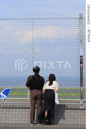 羽田空港の展望デッキ　展望デッキで離陸する飛行機を眺める利用客 104445042