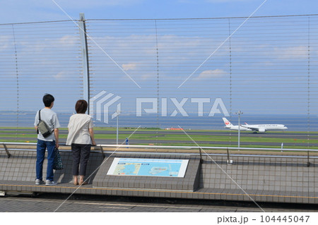 羽田空港の展望デッキ 展望デッキで離陸する飛行機を眺める利用客 羽田空港の展望デッキ 展望デッキで離陸する飛行機を眺める利用客 104445047