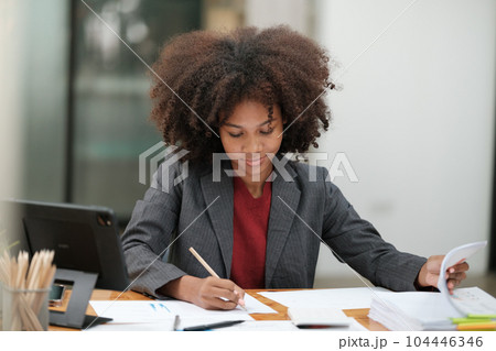 American African Woman working in the office with computer phone and Tablet. 104446346