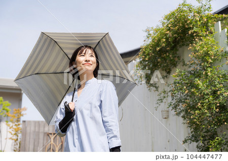日傘をさす女性の写真 104447477