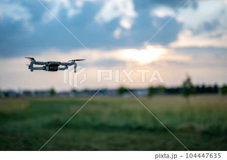 Drone hovering above the skyline as dusk approaches. Drone hovering above the skyline as dusk approaches. 104447635