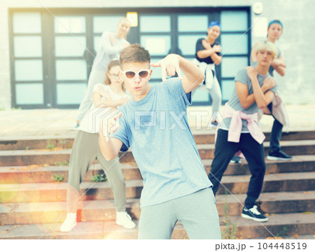 Teen boy dancing modern street dance with teenagers 104448519