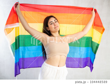 Young woman with LGBT flag posing in studio 104448589