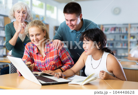 Mature female teacher asks the amused schoolchildren to behave a little quieter 104448628