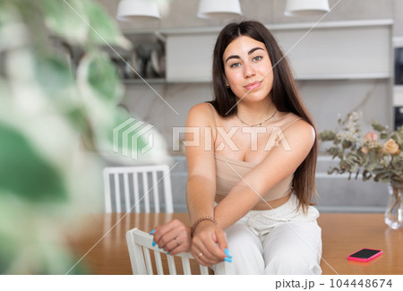 Young smiling woman posing in kitchen at home Young smiling woman posing in kitchen at home 104448674
