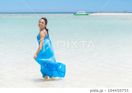 百合が浜を前に浅瀬をワンピースで歩く若い女性 104450755