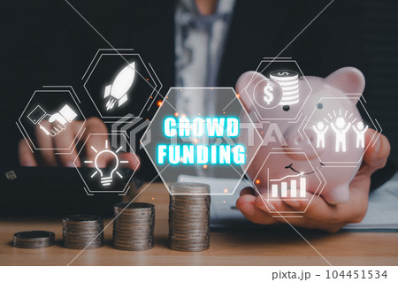Crowdfunding concept, Business person hand holding piggy bank with crowdfunding icon on virtual screen, Collaborative, Growth and return. 104451534
