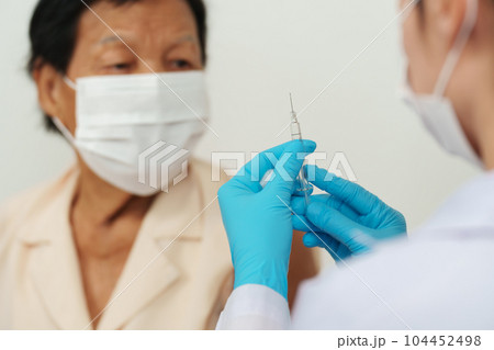 doctor make injection Covid-19 or coronavirus vaccine to senior patient in medical mask doctor make injection Covid-19 or coronavirus vaccine to senior patient in medical mask 104452498