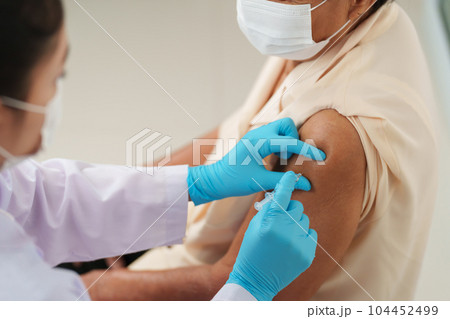 doctor make injection Covid-19 or coronavirus vaccine to senior patient in medical mask doctor make injection Covid-19 or coronavirus vaccine to senior patient in medical mask 104452499