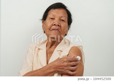 older senior woman showing cotton on arm after getting vaccine 104452500