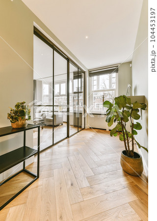 a living room with wood flooring and large glass doors leading to the balcony area in the room is empty a living room with wood flooring and large glass doors leading to the balcony area in the room is empty 104453197