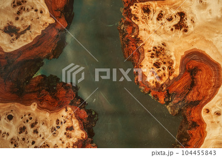 The background is made of wood and transparent epoxy resin in the middle with space for copying. Wooden table covered with epoxy resin. High quality photo 104455843