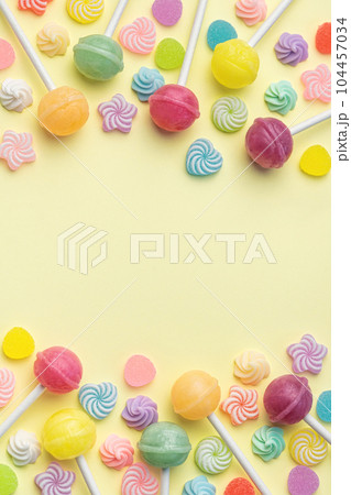 Sweet lollipops and candies on yellow background Sweet lollipops and candies on yellow background 104457034