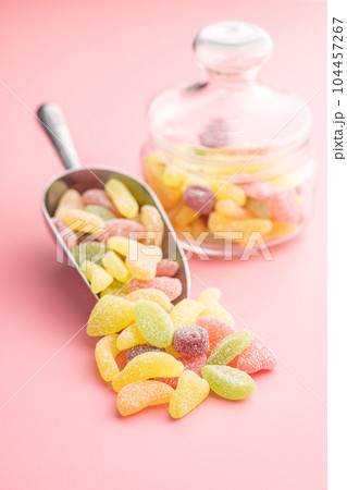 Mix of fruity jelly candy in scoop on pink background. 104457267