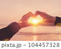 Female hands heart shape on nature bokeh sun light wave and blur tropical sunset beach abstract background. Copy space of happy love travel and freedom in nature concept. Vintage tone color style. 104457328