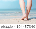 Close up woman legs walking on tropical beach with smooth wave abstract background. Travel vacation and freedom feel good concept. Vintage tone filter color style. 104457340