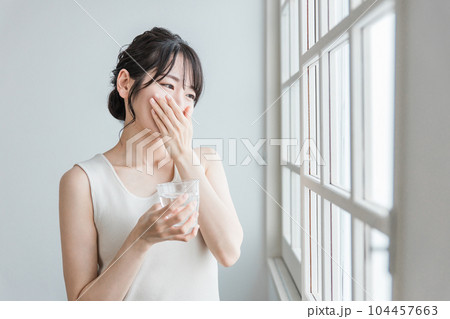薬を飲む頭痛・体調不良のアジア人女性 104457663