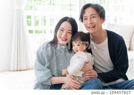 家で過ごす笑顔の3人家族（ファミリー・育児・子育て・赤ちゃん） 104457827