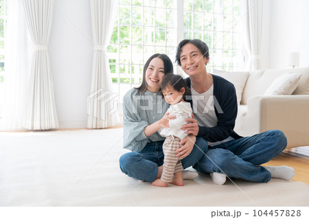 家で過ごす笑顔の3人家族（ファミリー・育児・子育て・赤ちゃん） 104457828