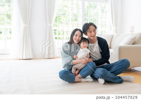 家で過ごす笑顔の3人家族（ファミリー・育児・子育て・赤ちゃん） 104457829