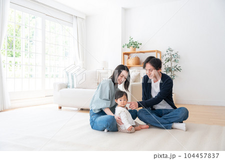 家で過ごす笑顔の3人家族（ファミリー・育児・子育て・赤ちゃん） 104457837