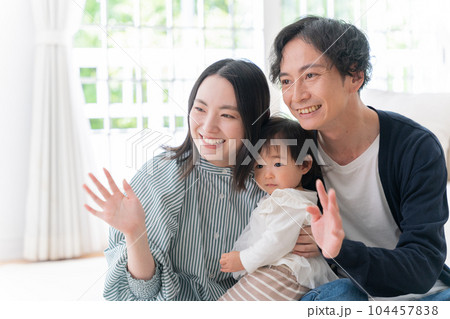 家で過ごす笑顔の3人家族（ファミリー・育児・子育て・赤ちゃん） 104457838