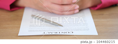 Businesswoman putting hands on contract agreement and silver pen Businesswoman putting hands on contract agreement and silver pen 104460215