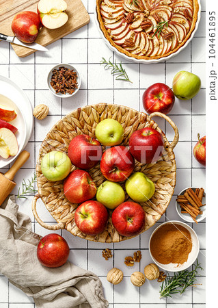 Apple. Fresh raw juicy red and green apples in a basket on a kitchen table with ingredients for cooking Thanksgiving autumn season apple pie, top view 104461895