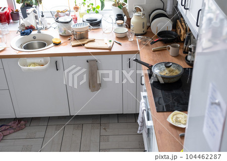 A mess in the kitchen, dirty dishes on the table, scattered things, unsanitary conditions. kitchen is untidy, everyday life A mess in the kitchen, dirty dishes on the table, scattered things, unsanitary conditions. kitchen is untidy, everyday life 104462287