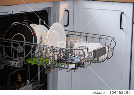 A lot of dirty dishes in the dishwasher. Helping the hostess, economy and ecology. Cleaning in the kitchen 104462296