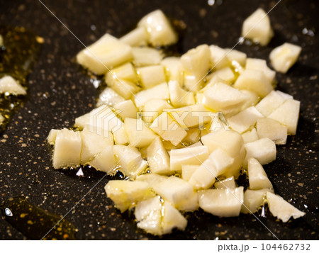 にんにく(粗みじん切り)をオリーブオイルで炒める調理シーン。 104462732