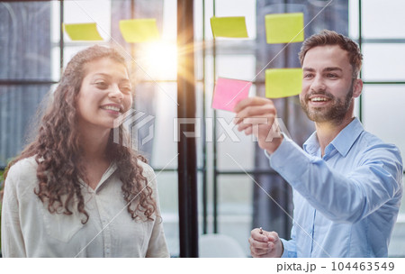 Business people talking in the hallway of the modern office building with employees working behind glass partitions. Work in a large business corporation 104463549