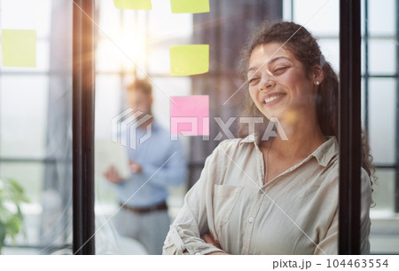 Smiling business woman looking out the window. 104463554