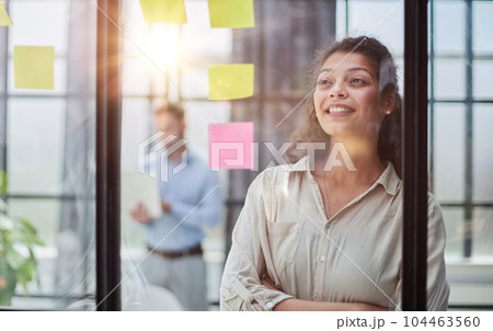 Smiling business woman looking out the window. 104463560