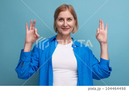smiling mature woman thinking brilliant idea on blue background with copyspace 104464498