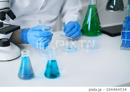 Science and medicine, scientist analyzing and dropping a sample into a glassware, experiments containing chemical liquid in laboratory on glassware, innovative and technology. 104464534