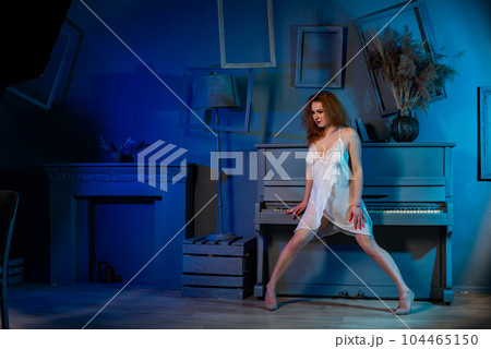naked woman in a semi transparent white dress near the piano in the studio naked woman in a semi transparent white dress near the piano in the studio 104465150
