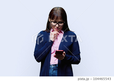 Middle aged woman using smartphone, on white background 104465543