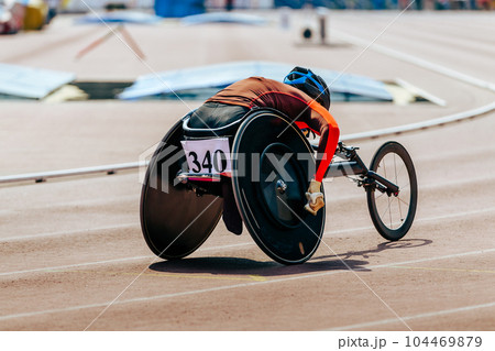 female athlete in wheelchair racing track stadium in para athletics competition, summer sports games 104469879