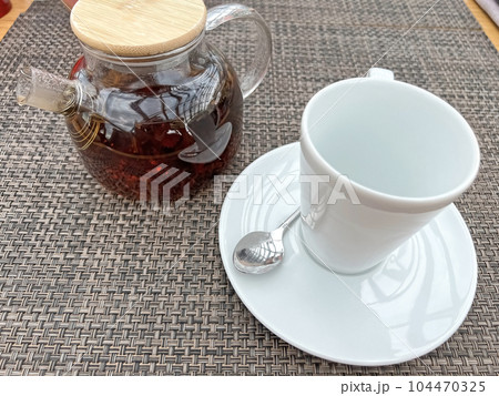 Teapot with tea and a cup on the table Teapot with tea and a cup on the table 104470325