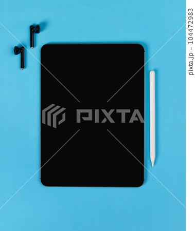 Flat lay top view blank screen digital tablet on blue background. Home office workspace 104472983